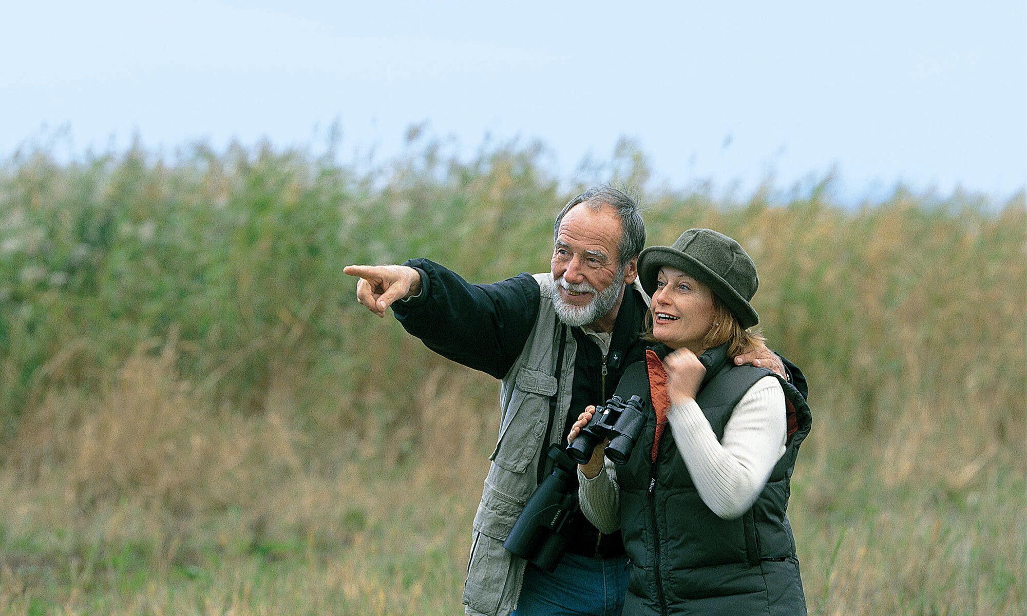 An elderly couple birdwatching on holiday in Burgenland.