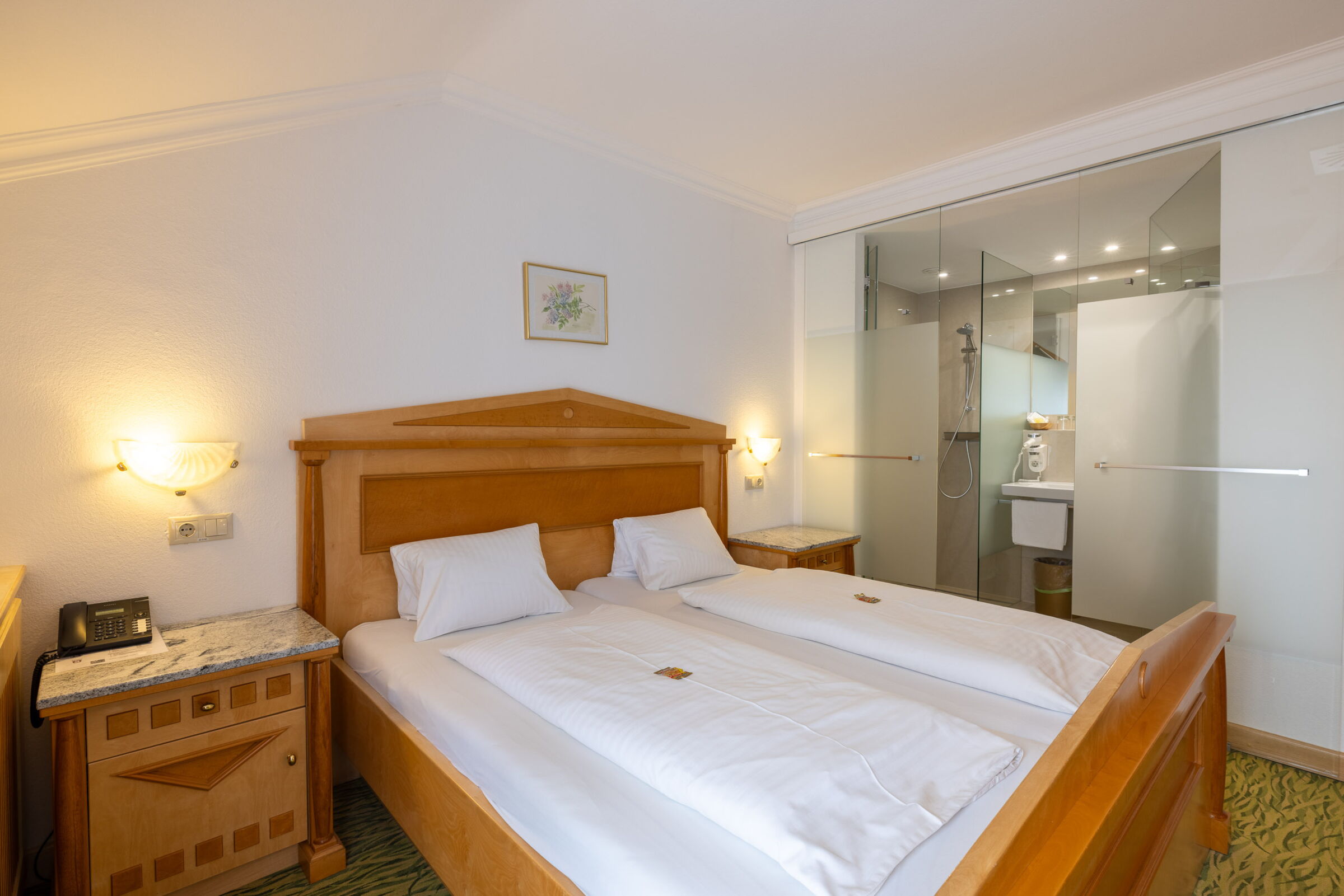 Das Flieder Zimmer mit einem Doppelbett und dem daneben liegenden Badezimmer; © Manfred Sodia Photography
