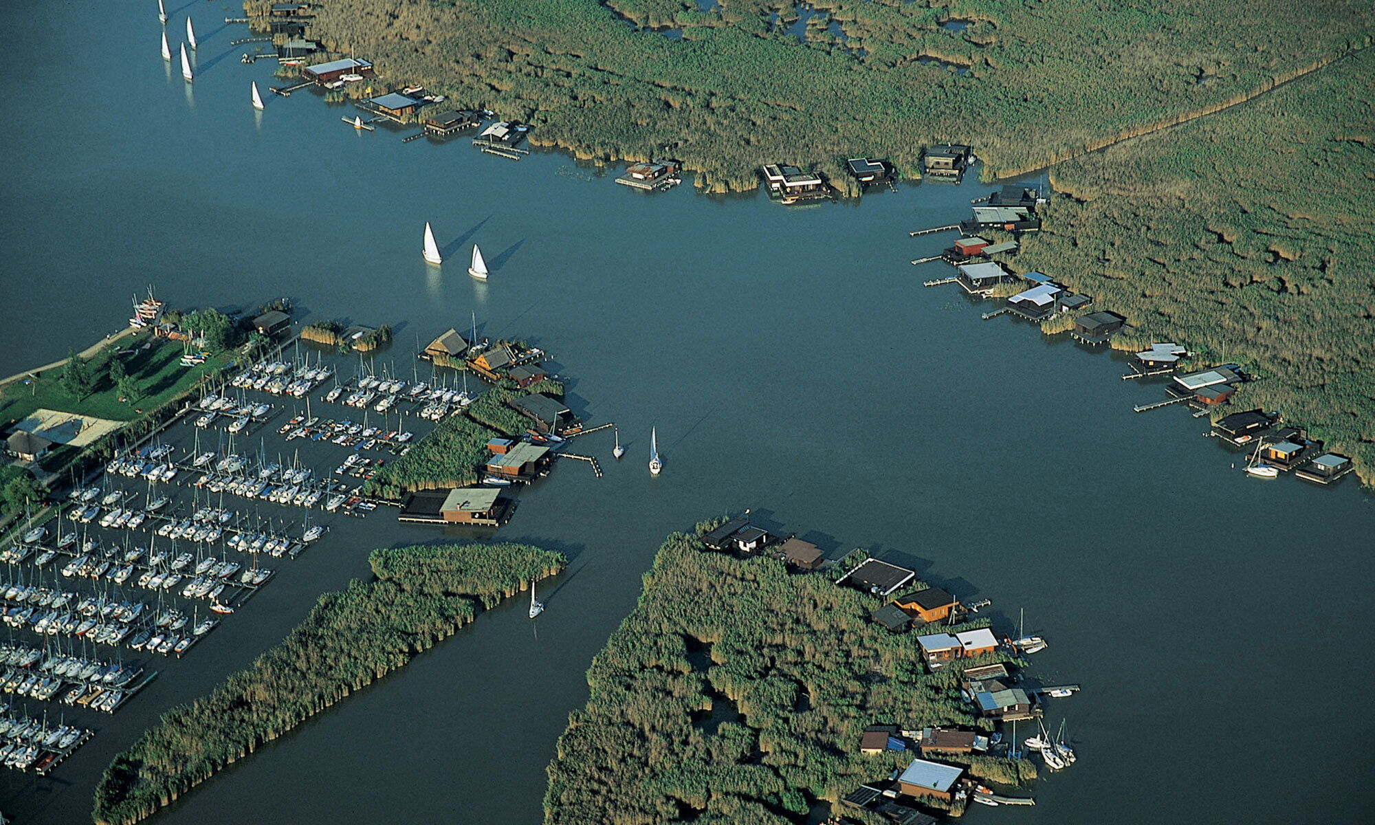 Aerial view of Lake Neusiedl with boat moorings and moving sailing boats