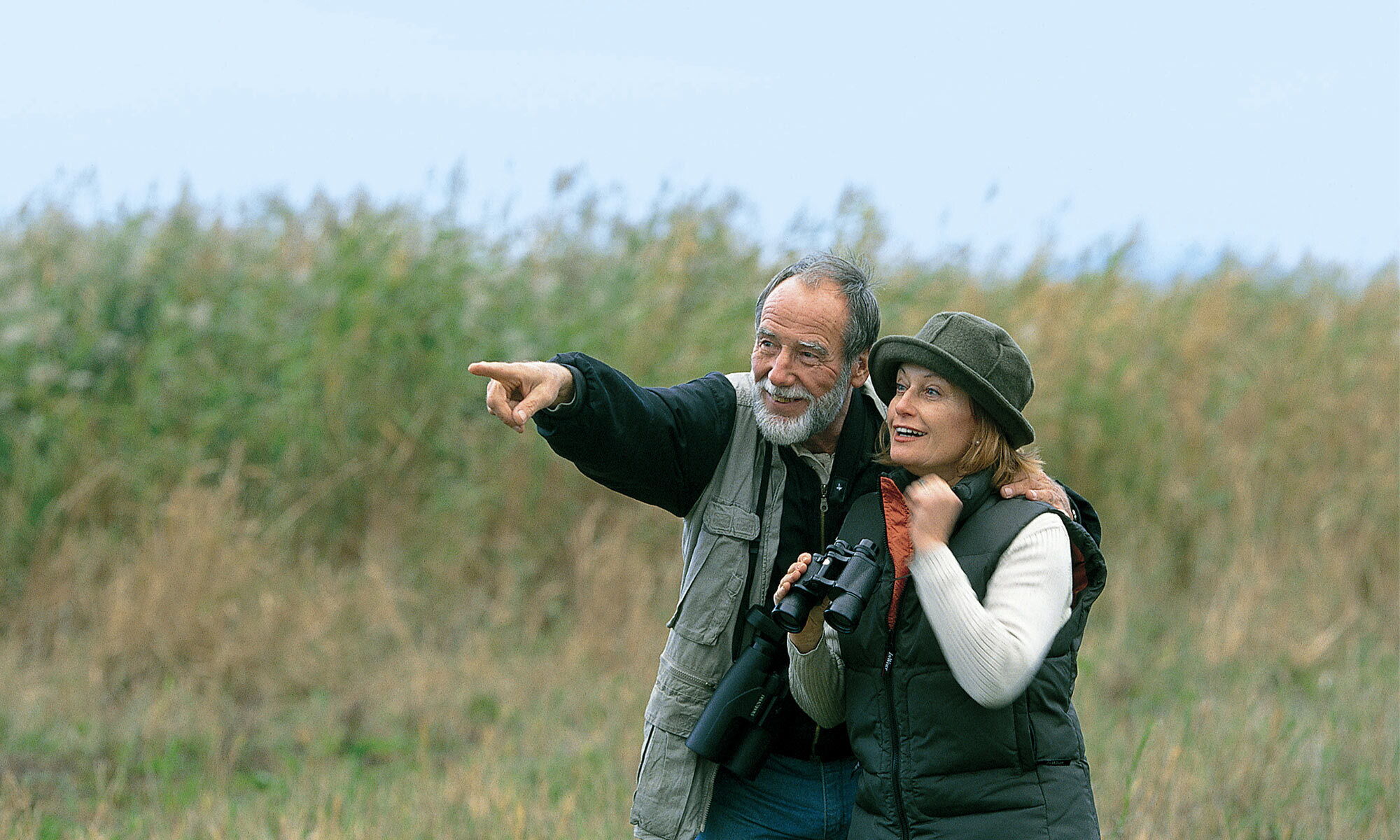 An elderly couple birdwatching on holiday in Burgenland.
