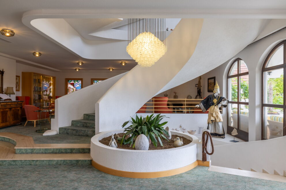 Lobby des Hotels Das-Schmidt im Burgenland mit einer schönen Hängeleuchte und einer stilvollen Wendeltreppe © Manfred Sodia Photography