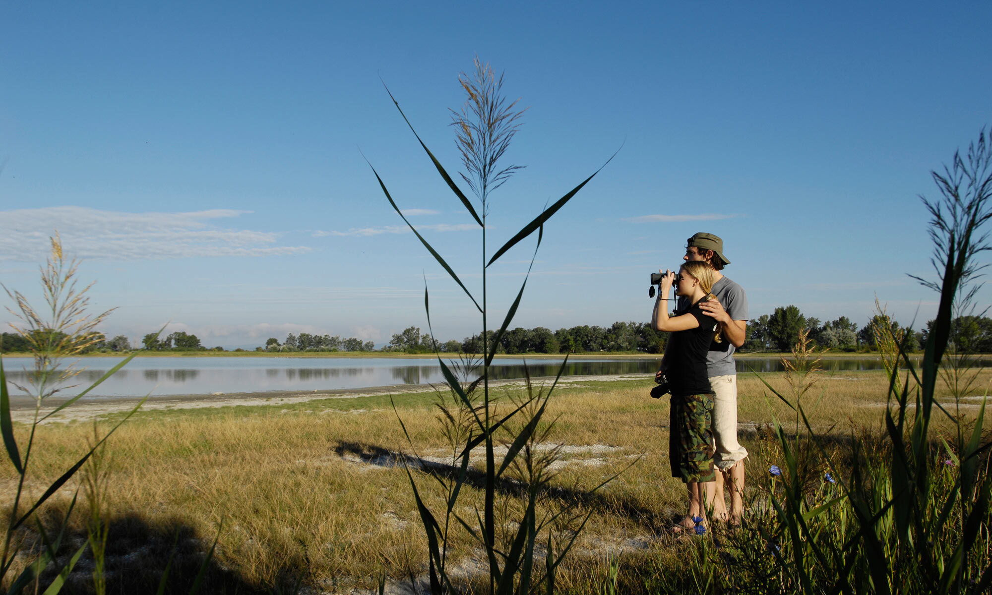 Ein Paar auf unabhängiger Safari mit Fernglas im Naturschutzgebiet Neusiedlersee im Burgenland