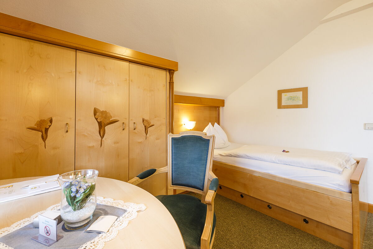 Das Vergissmeinnicht Zimmer mit einem Einzelbett und einem großen Schrank im Privathotel Das-Schmidt