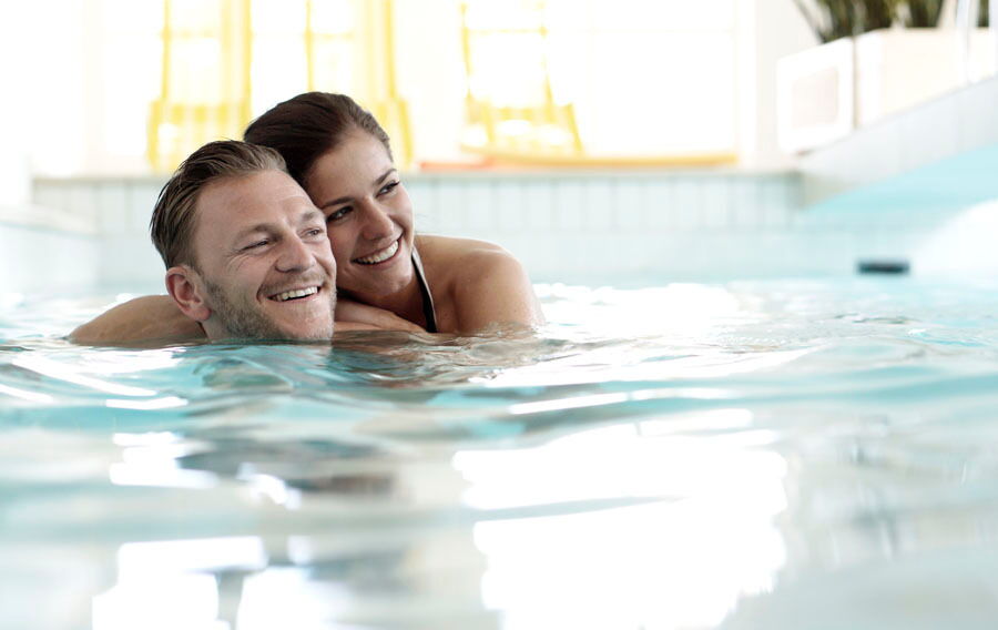 Couple swimming in the indoor pool of the Das-Schmidt wellness hotel on Lake Neusiedl