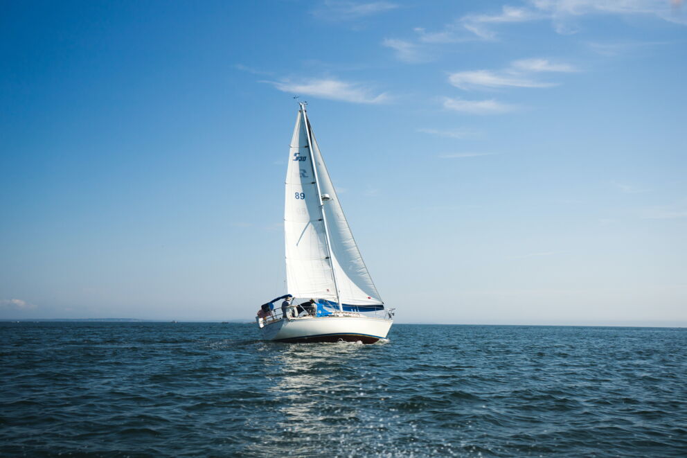 Ein weißes Segelboot im Wasser; © Evan Smogor auf Unsplash