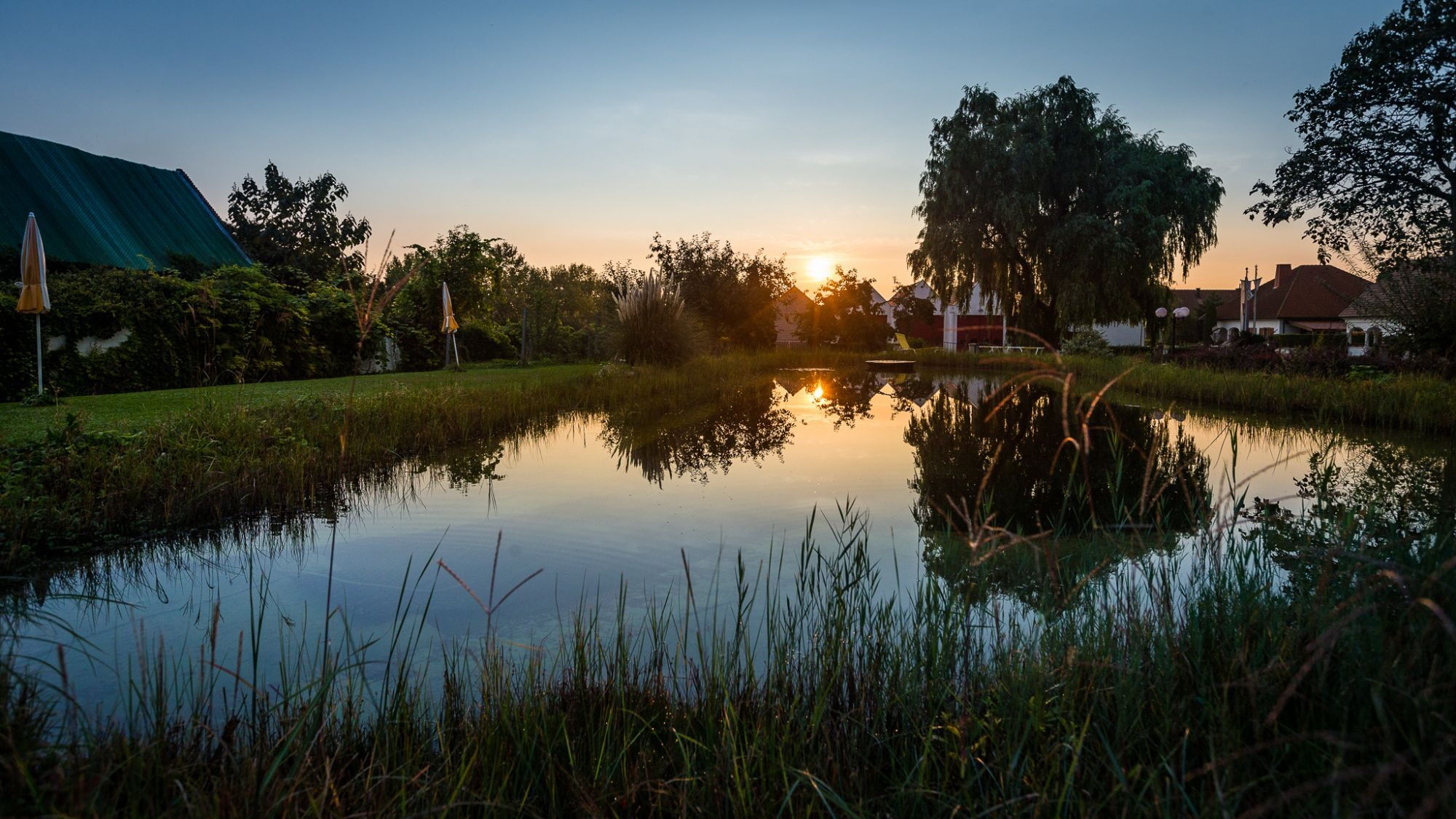 Blick auf den Sonnenuntergang am Teich bei Das Schmidt