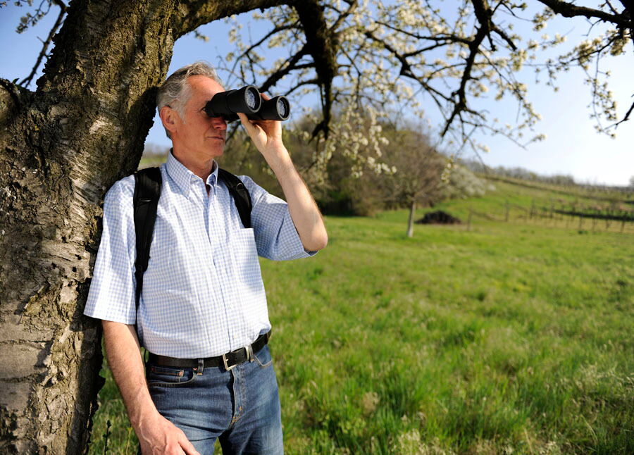 Ein Mann mit einem Fernglas im Naturparadies am Neusiedlersee im Burgenland