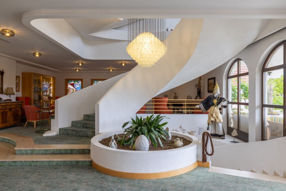 Lobby des Hotels Das-Schmidt im Burgenland mit einer schönen Hängeleuchte und einer stilvollen Wendeltreppe © Manfred Sodia Photography