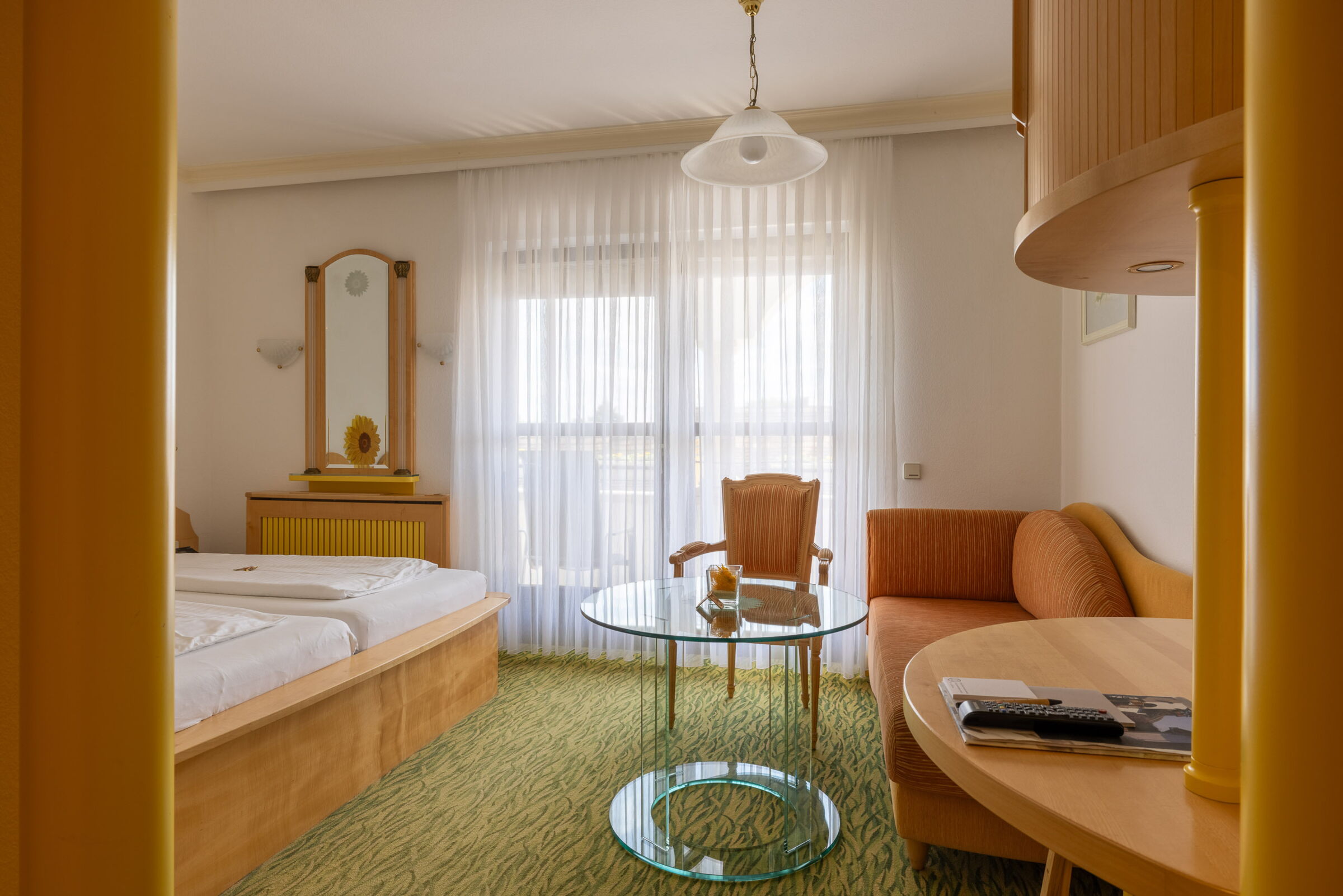 Das Sonnenblumen Zimmer mit einem Doppelbett und einer Couch im Privathotel Das-Schmidt;© Manfred Sodia Photography