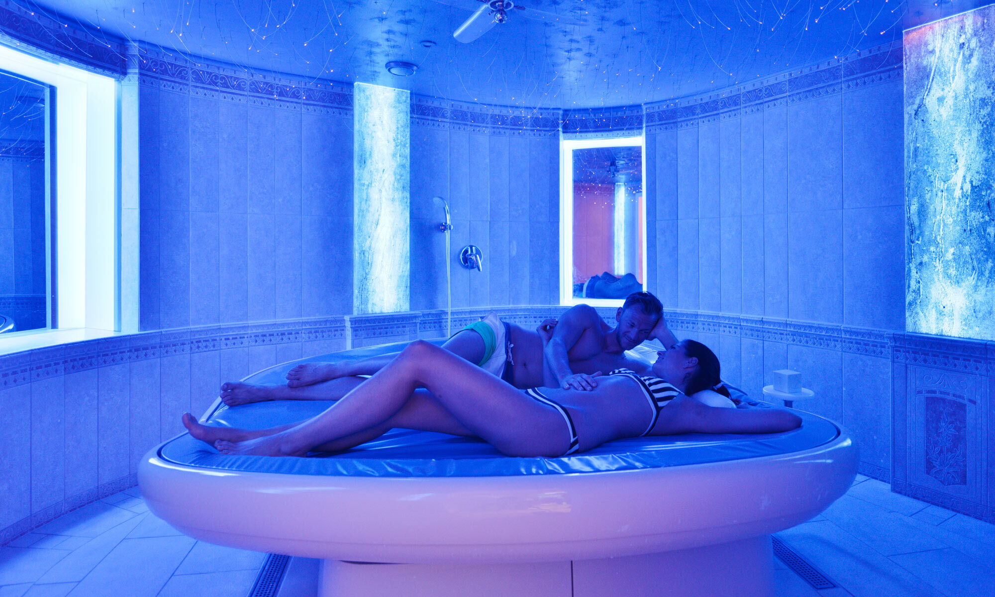 A couple enjoys the hotel's own waterbed in the spa area of the private hotel Das Schmidt