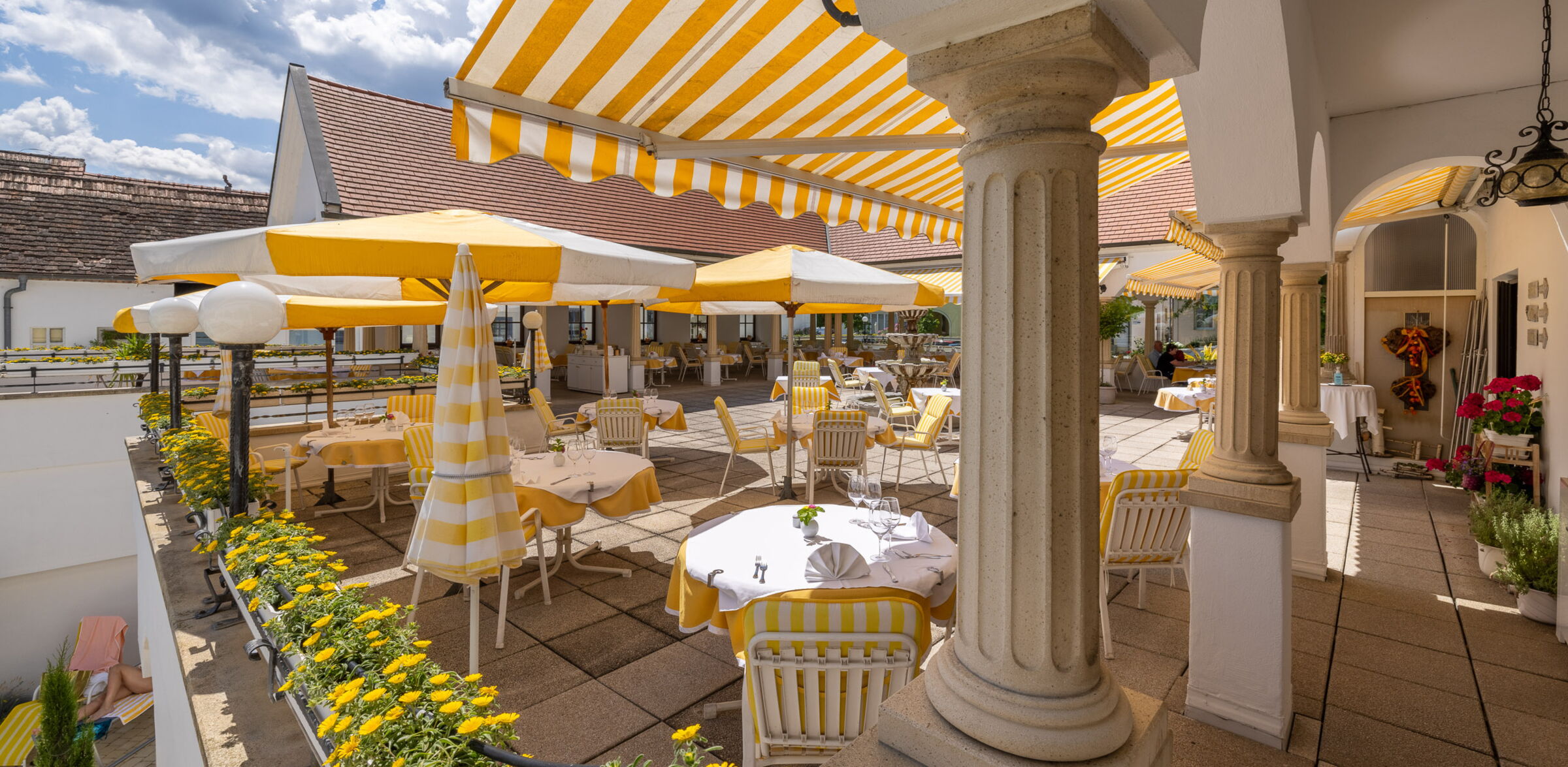 Sonnenterrasse mit gelben Sesseln und Sonnenschirmen laden im Hotel Das-Schmidt zum Sonnenbaden ein © Manfred Sodia Photography