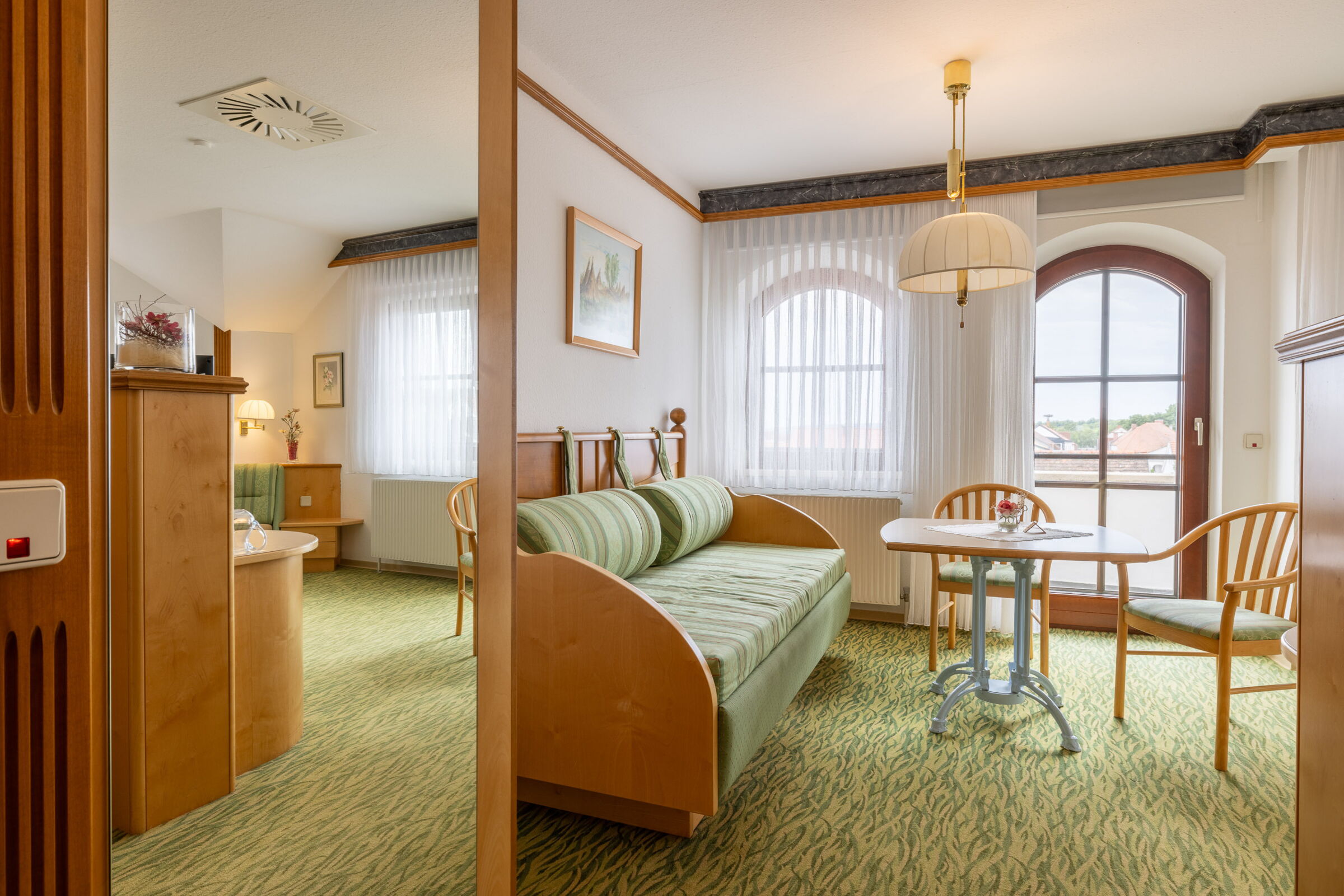 Ein ausgestattetes Zimmer mit Couch, Tisch, Sesseln und vielen mehr Möbeln im Hotel Das Schmidt in Mörbisch; © Manfred Sodia Photography